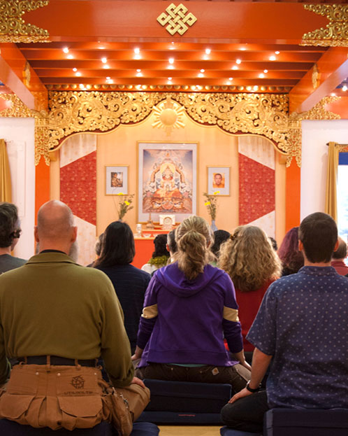 Meditators sit in Main Meditation Hall at Karme Choling Meditation Retreat Center